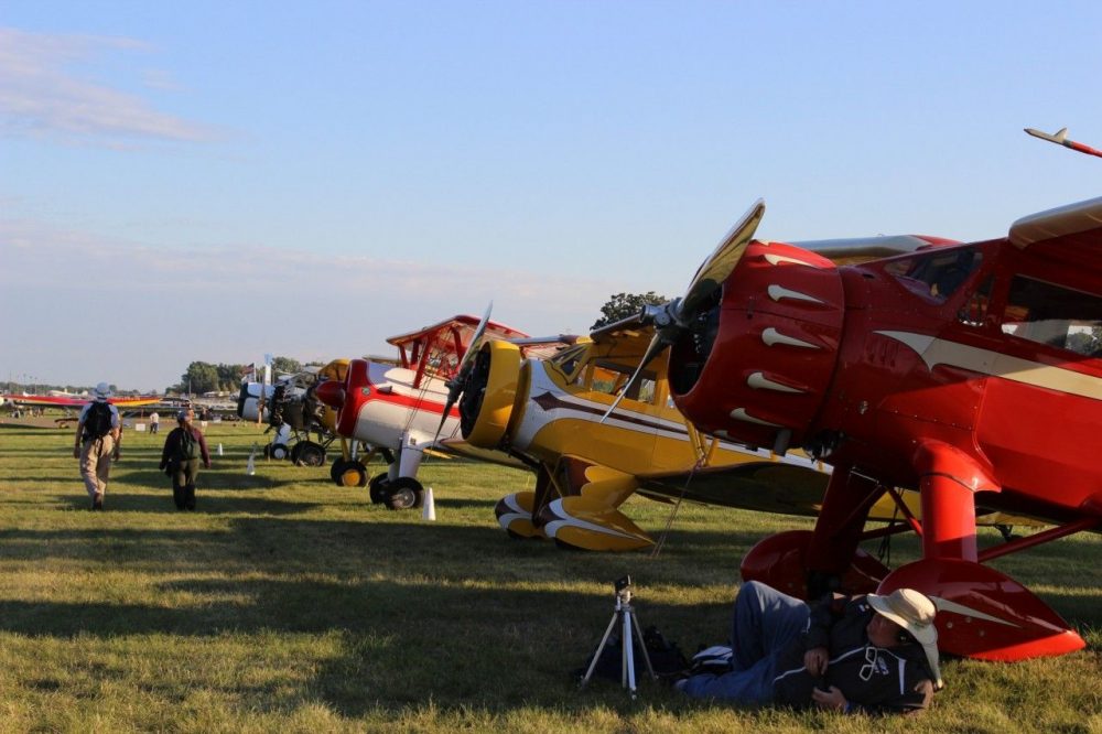 Vintage planes lined up in a field at AirVentures in Oshkosh, WI