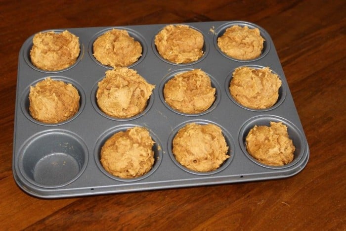 11 pumpkin muffins in a muffin tin (one pumpkin muffin is missing)