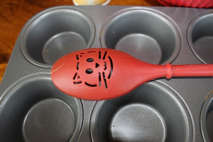 muffin tin and red spoon with a cat face cutout