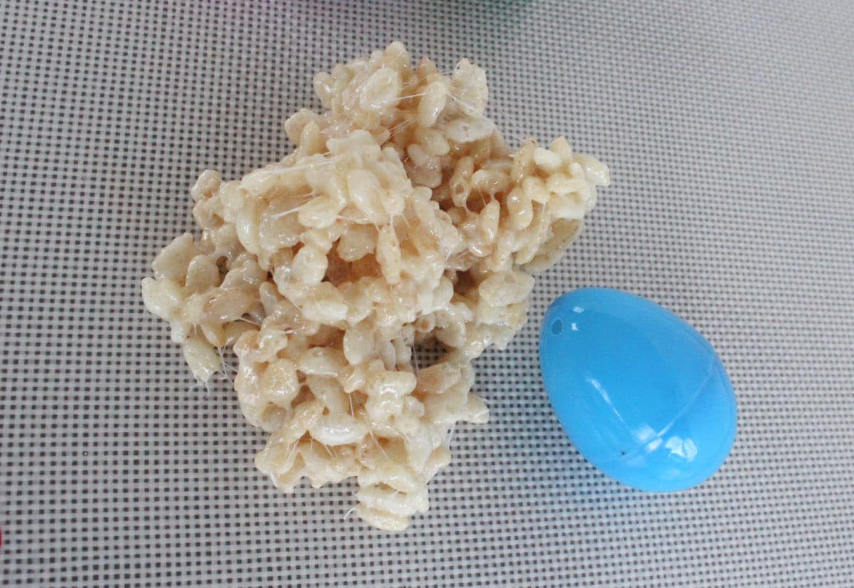 a portion of rice krispie cereal with marshmallow ready to cover plastic egg