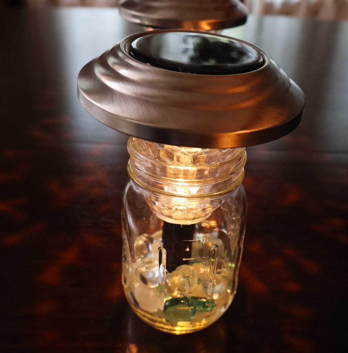 solar light placed on top of mason jar that contains marbles for weight.