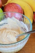 peanut butter fruit dip with apples and bananas in the background