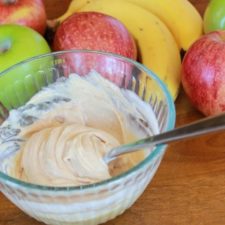 peanut butter fruit dip with apples and bananas in the background