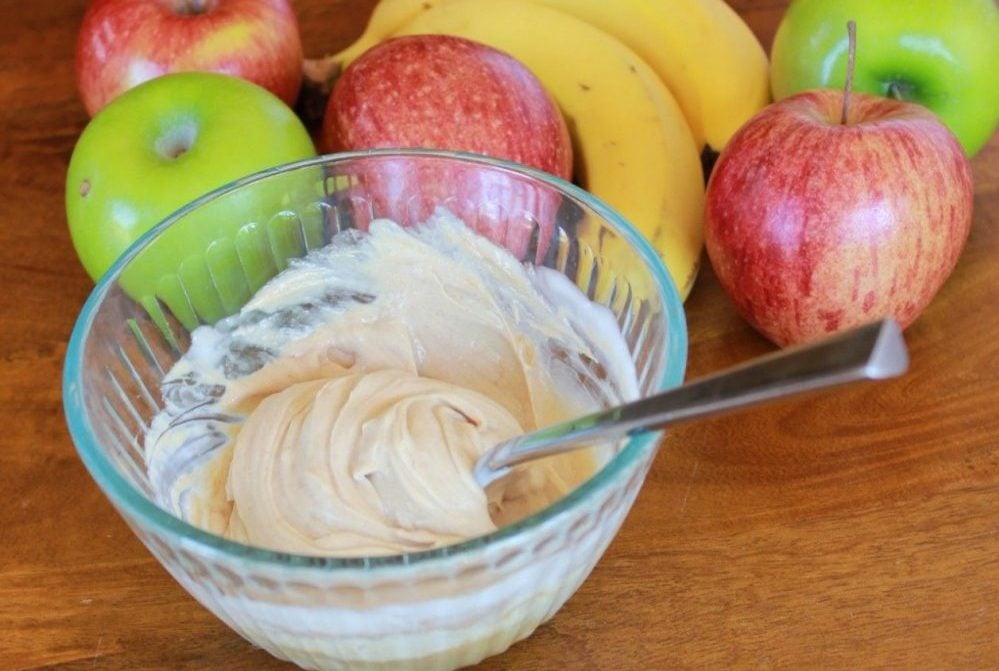 peanut butter fruit dip with apples and bananas in the background
