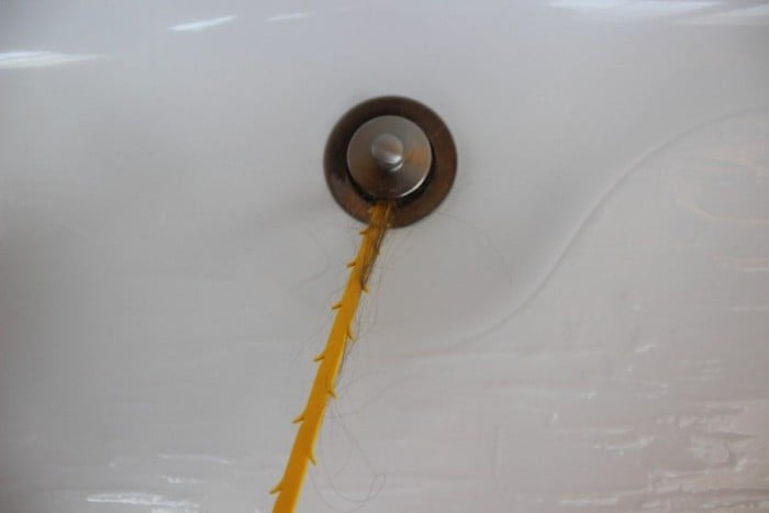 Plastic tool pulls out what is clogging the bathtub drain.