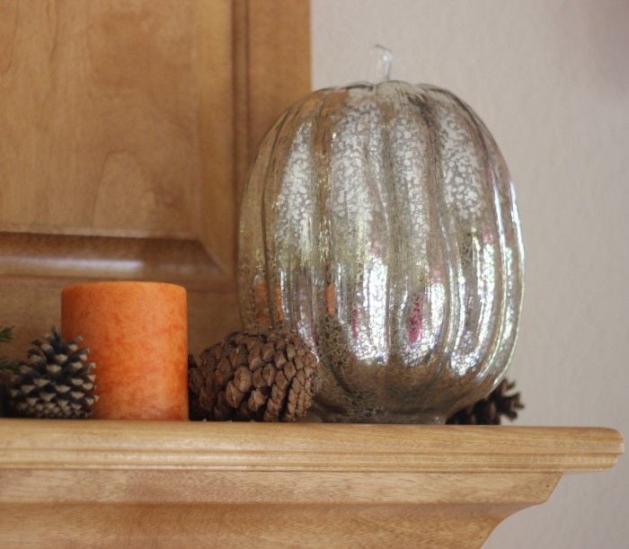 fall mantle with orange candles and mercury glass pumpkins