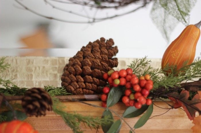 fall garland wit pretty pinecones, orange berries and colorful small gourds