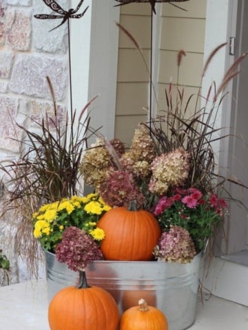 fall planter with grasses and pumpkins