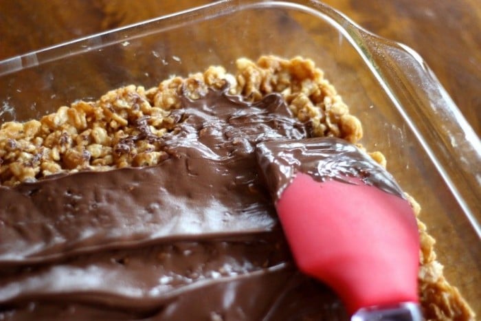 spreading the melted chocolate and butterscotch chips on the cereal layer