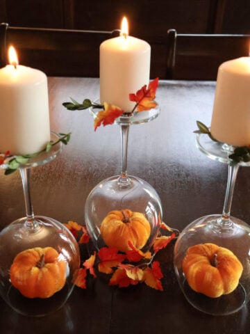 Centerpiece using wine glasses, fall decor and candles on the upside down wine glasses.