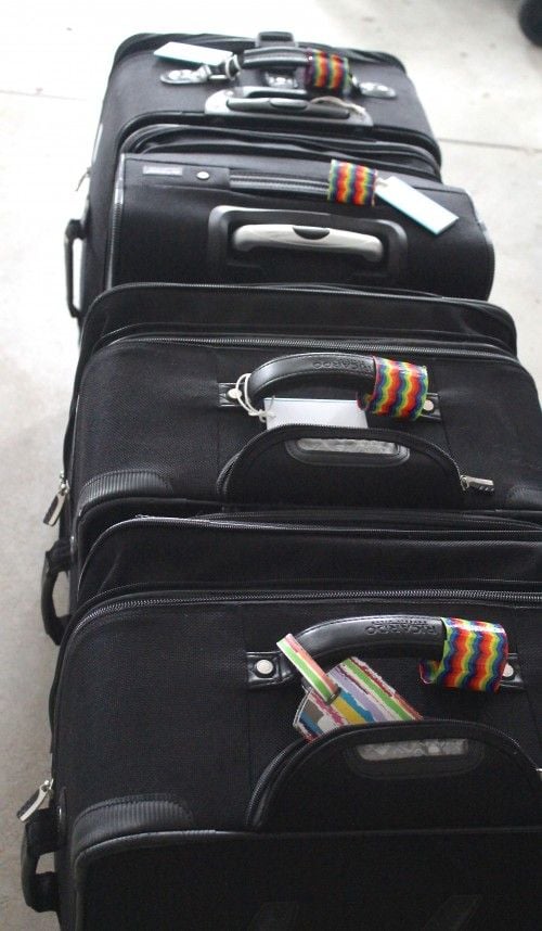 colorful piece of duct tape taped around handle of suitcase