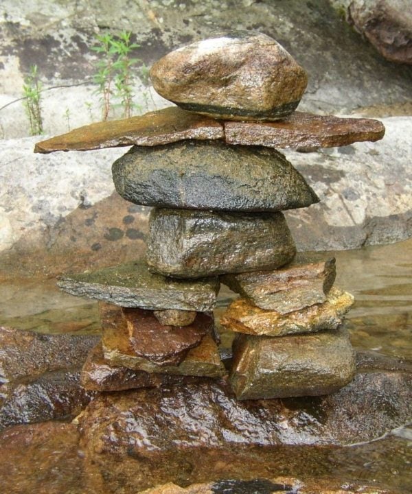 Inuksuk - stone man in the water near a lake shore