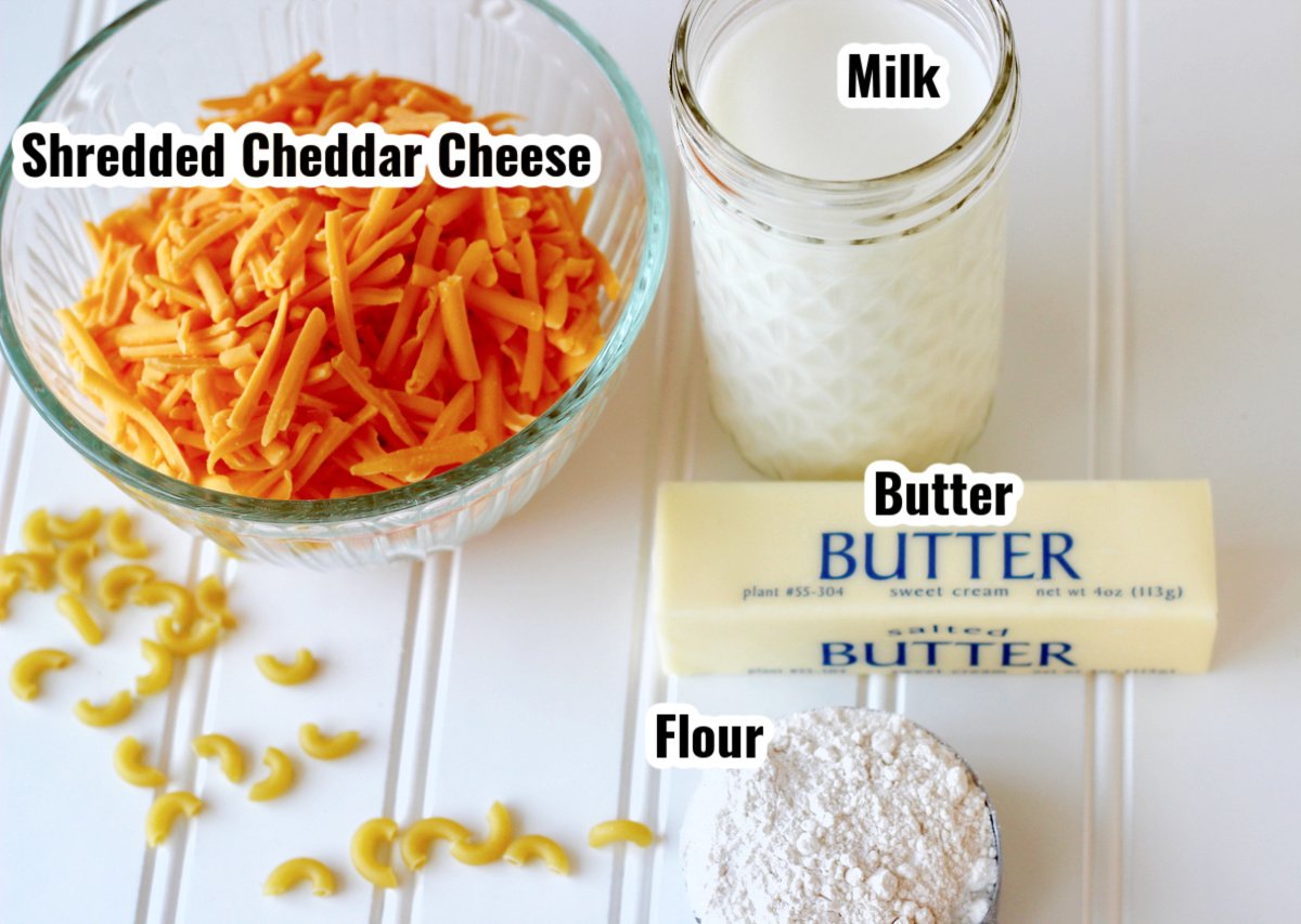 Mac and cheese ingredients including shredded cheddar, milk, butter and flour.