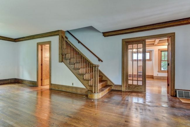 My fixer upper living room. The beautiful staircase and wooden trim greet you as you come into the house.