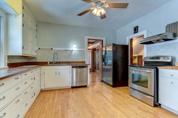 Original kitchen with old white cabinets and maple flooring