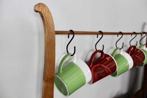 Vintage towel bar is now used to hang coffee mugs on this coffee bar.