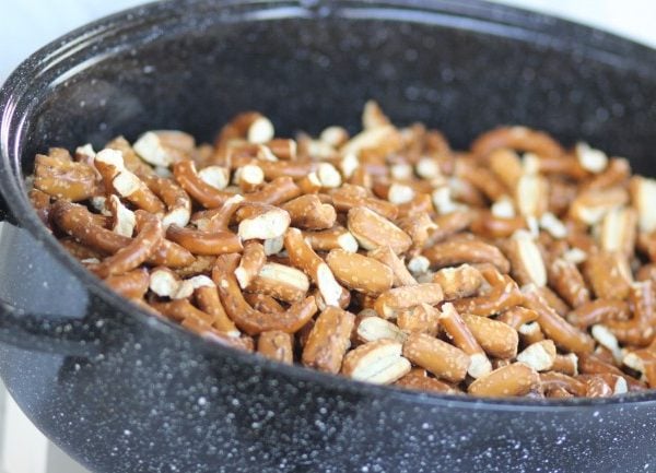 Put broken pretzels and pretzel bites into a roasting pan to mix