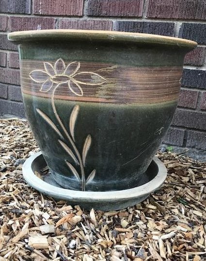 dark green planter with flower etched into it.