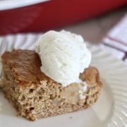 A piece of apple cake with a scoop of vanilla cake on top.