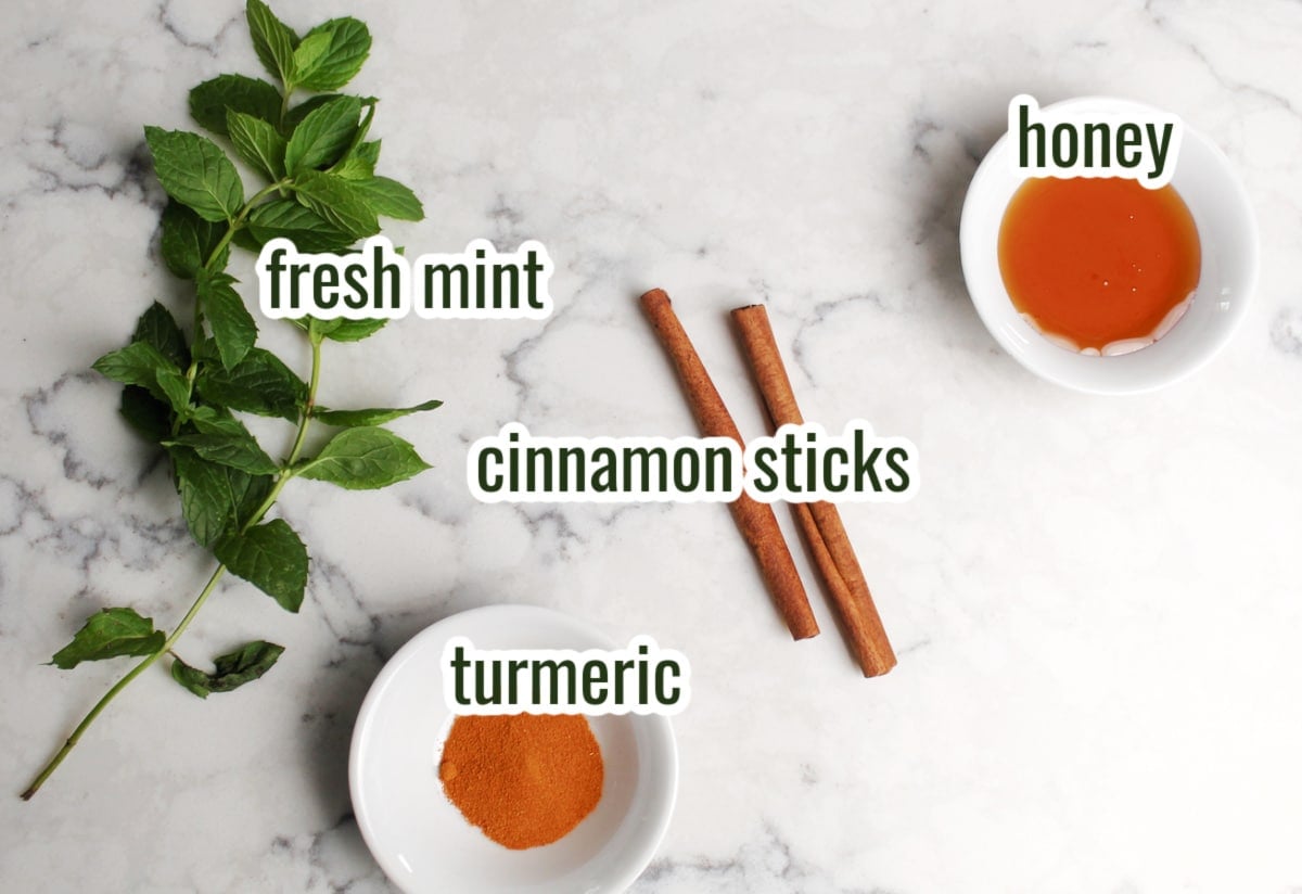ingredients for ginger lemon tea.  Options shown include honey, fresh mint, cinnamon sticks and turmeric.