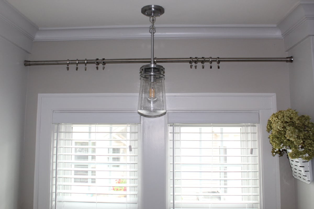 a shower rod with curtain clips above the kitchen window.