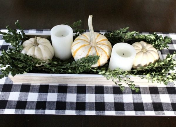 fall dining room table centerpiece with white pumpkins, candles and some green boxwood branches