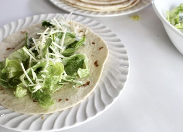 A Caesar Salad with grated parmesan on a fresh tortilla.