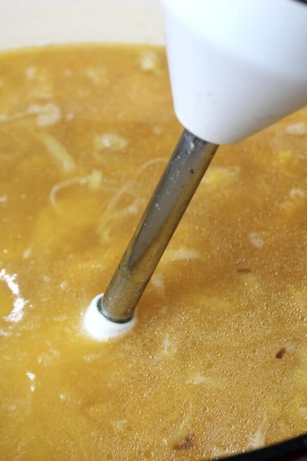 butternut squash soup being blended with imersion blender