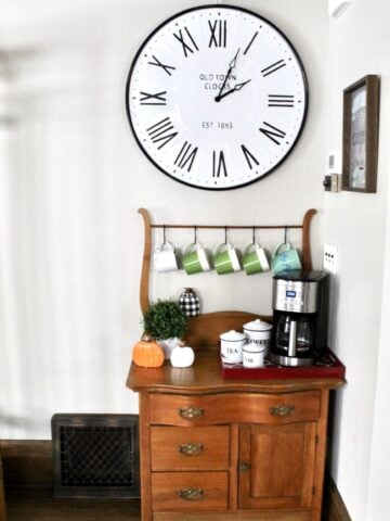 Coffee bar using small vintage side table with large white farmhouse clock above.