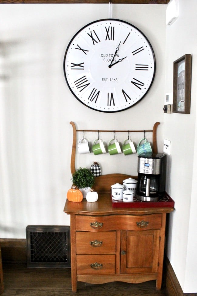 Coffee bar using small vintage side table with large white farmhouse clock above.