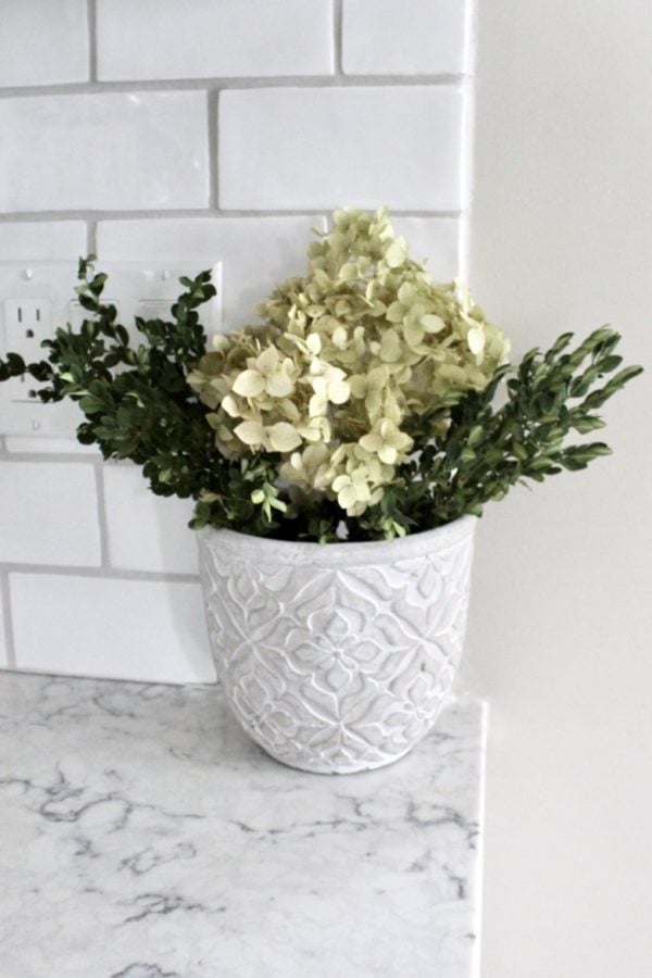 Planter fulled with dried boxwood and hydrangeas.