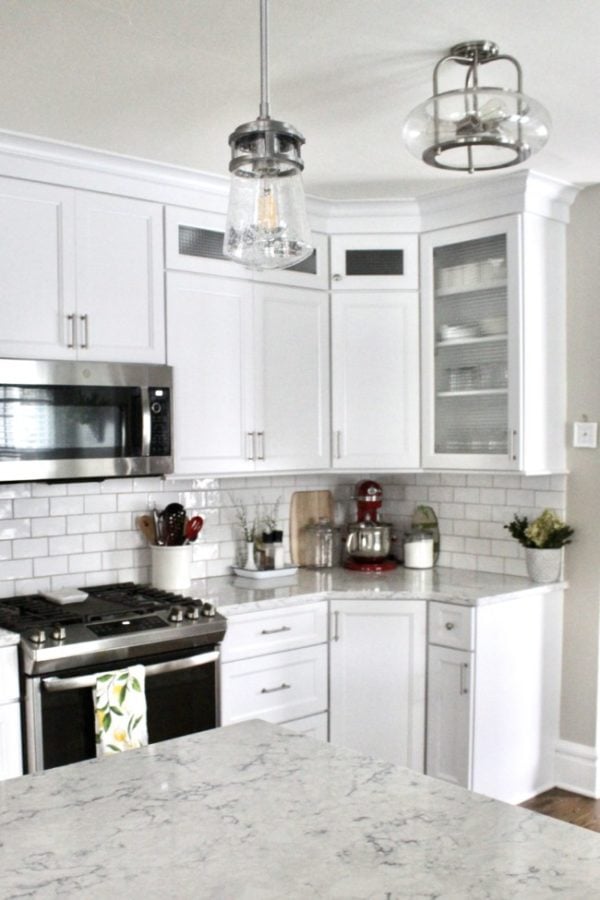 a white kitchen with white cabinets that extend to the ceiling