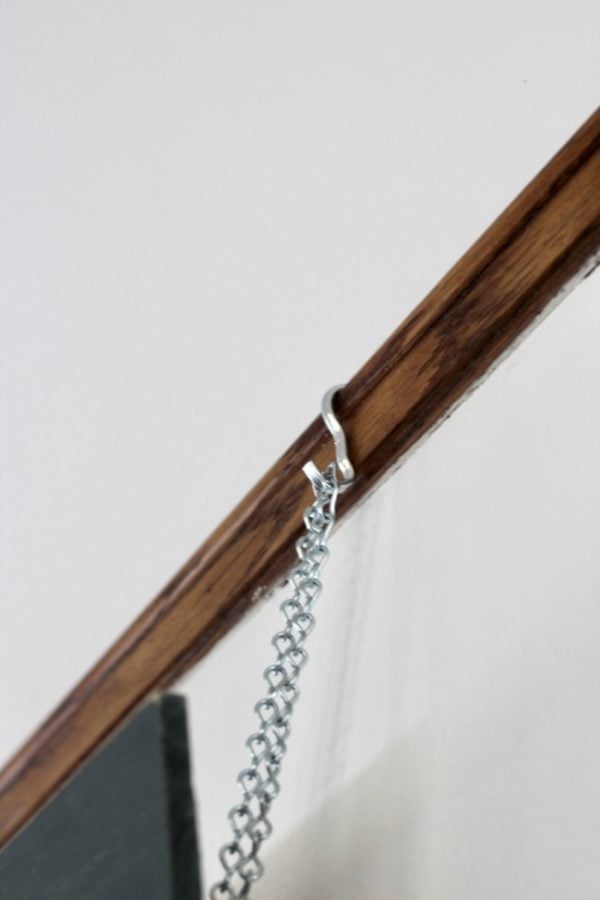 picture hook with chain hanging on a picture rail molding.