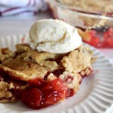 cherry cobbler with ice cream on a white plate