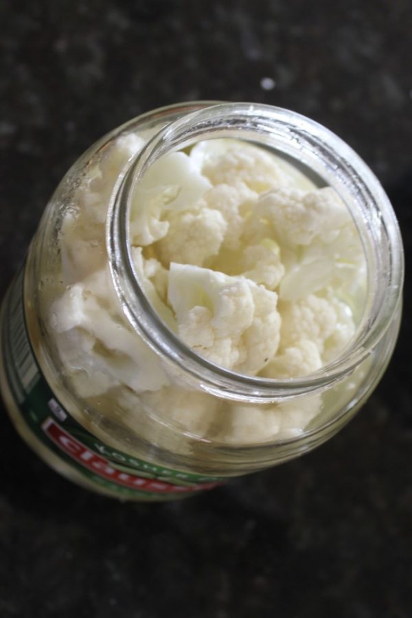 cauliflower pieces filling up a pickle jar