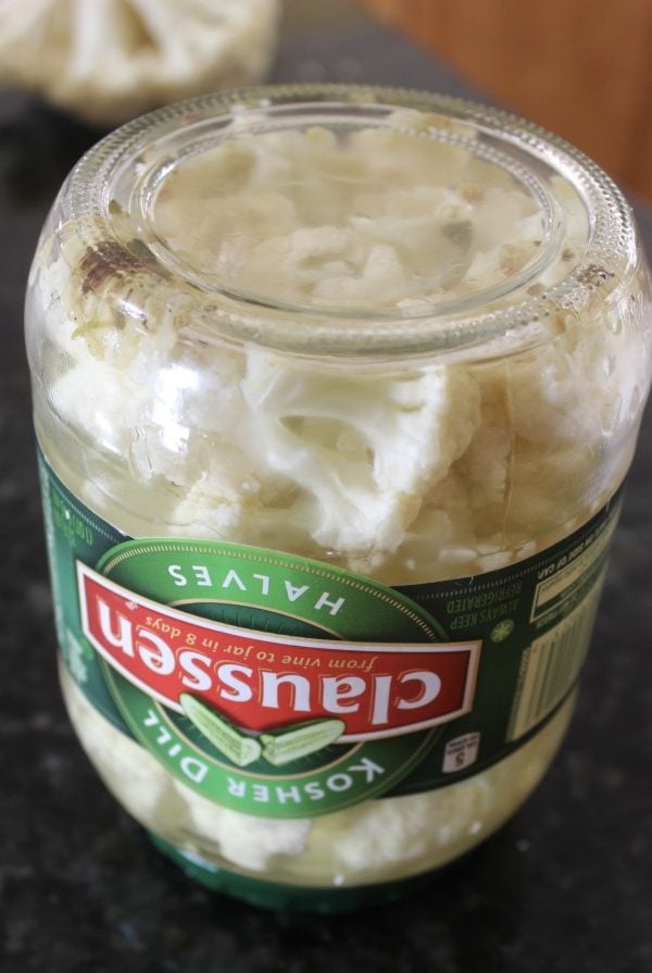 Upside down pickle jar full of cauliflower pieces.