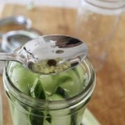 topping off the cucumber spears with chopped garlic and pepercorn.