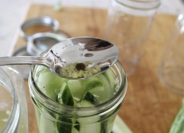 topping off the cucumber spears with chopped garlic and pepercorn.