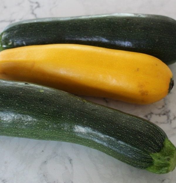 two green zucchini and one yellow summer squash