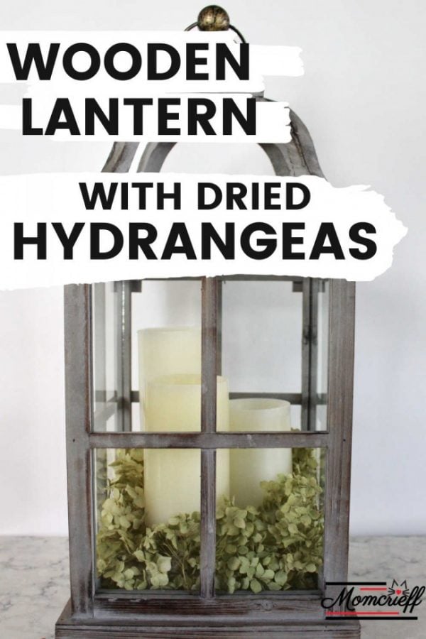 wooden lantern filled with white candles and dried hydrangeas