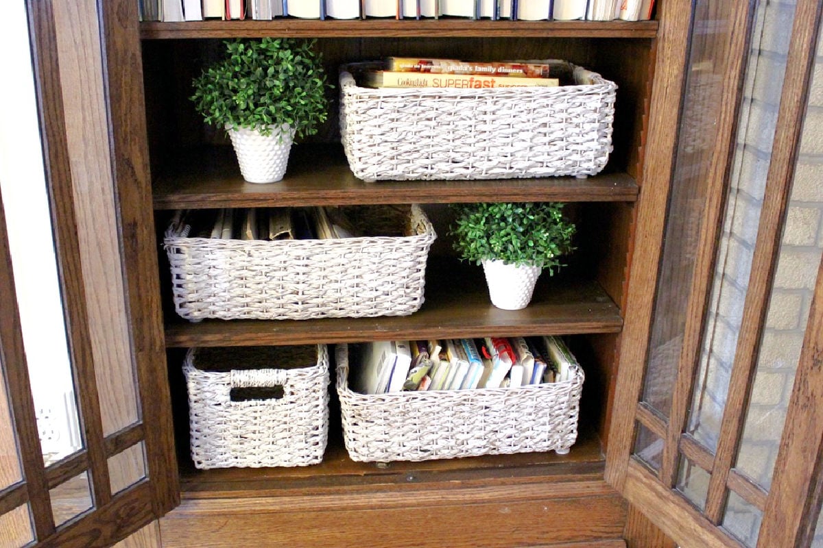 Looking inside a built in with white baskets and two small white planters.
