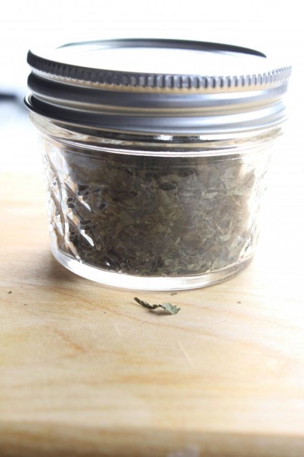small mason jar with crushed dried basil