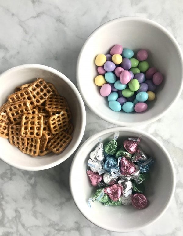 pretzels, hershey kisses and pastel colored M & M's in white bowls