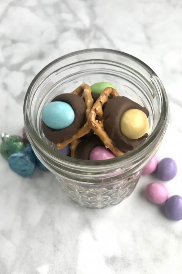 mason jar with pretzels with M&M's and Hershey kisses on them. 
