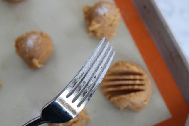 fork with sugar on it to be used to flatten the peanut butter cookies