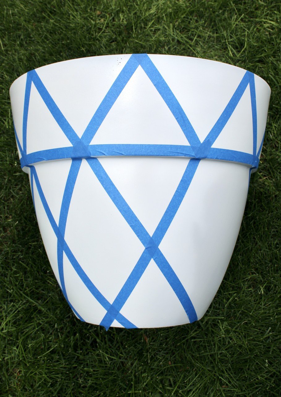 putting painters tape on planter to create a painted design