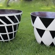 black and white painted planters on the grass