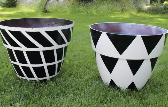 black and white painted planters on the grass