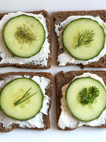 cucumber appetizer on rye cocktail bread topped with herbs