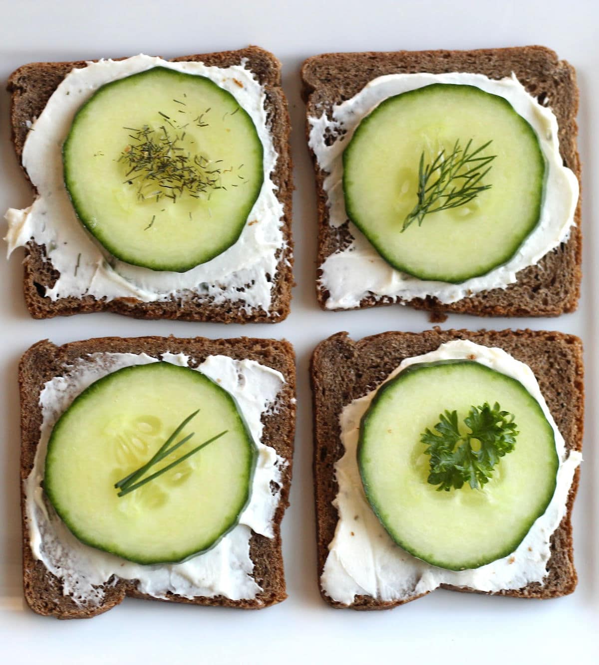 cucumber appetizer on rye cocktail bread topped with herbs